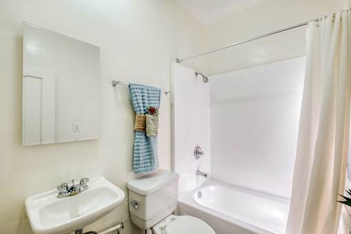 A white bathroom with a sink, toilet, and bathtub.