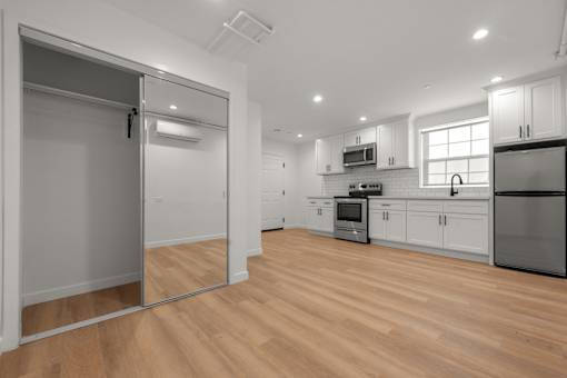 A kitchen with wooden floors and white walls.