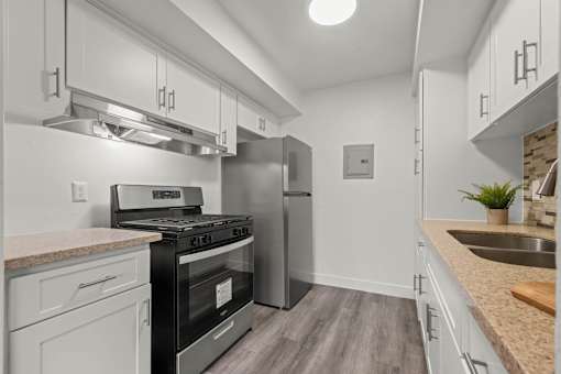A modern kitchen with a stove, refrigerator, and sink.