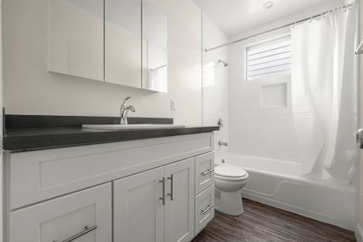 A white bathroom with a sink, toilet, and bathtub.
