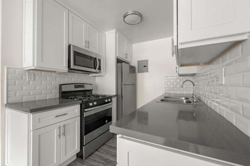 a kitchen with white cabinets and stainless steel appliances