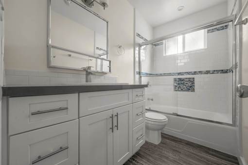 a bathroom with white cabinets and a shower and a toilet