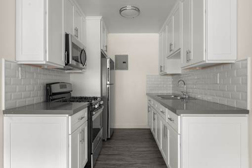 a kitchen with white cabinets and black counter tops