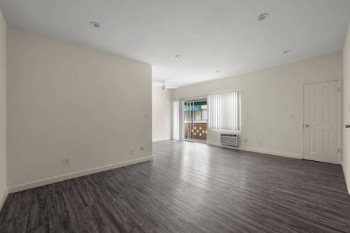 the living room and dining room of a new home with white walls and wood floors