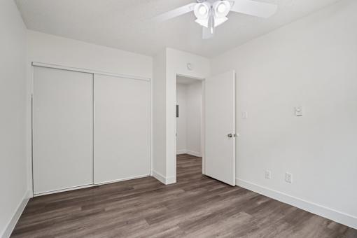 A room with a ceiling fan and a door.
