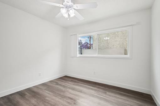 A room with a ceiling fan and a window.