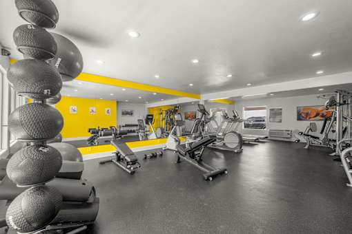 A gym with a variety of exercise equipment including treadmills, weights, and exercise balls at Sunset Square, West Covina, 91790