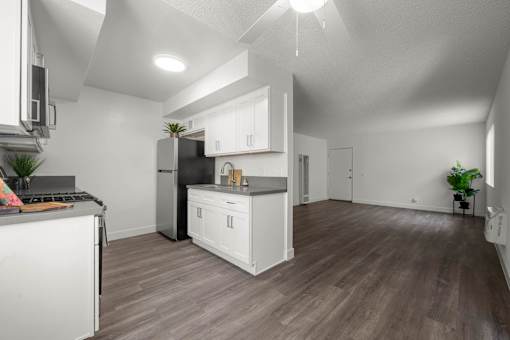 A modern kitchen with white appliances and wooden floors at Sunset Square, West Covina, 91790