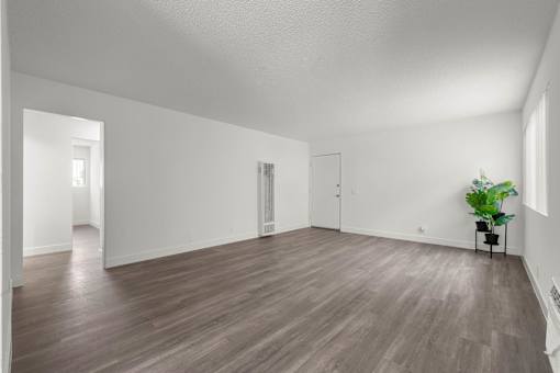 A room with wooden flooring and white walls at Sunset Square, West Covina, 91790