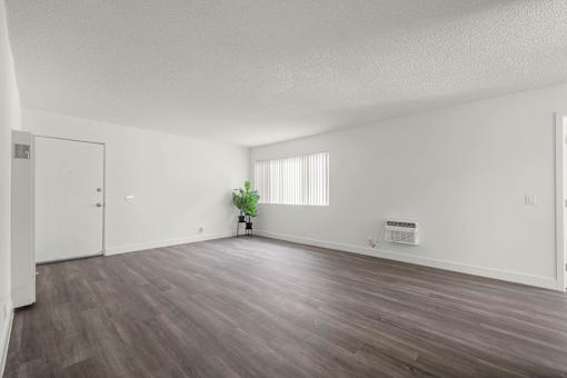 A room with wooden flooring and a small plant in the corner at Sunset Square, West Covina, 91790