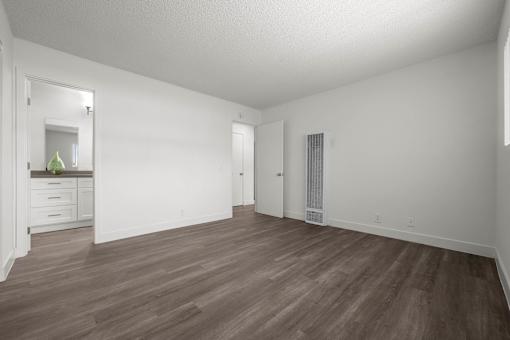 A room with wooden flooring and white walls at Sunset Square, West Covina, 91790