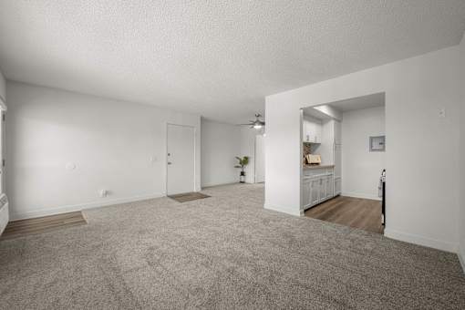 A spacious room with a grey carpet and white walls at Sunset Square, West Covina, 91790