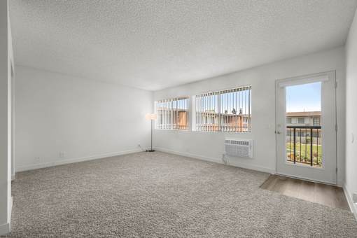 A room with a carpeted floor and a door leading to a balcony at Sunset Square, West Covina, 91790