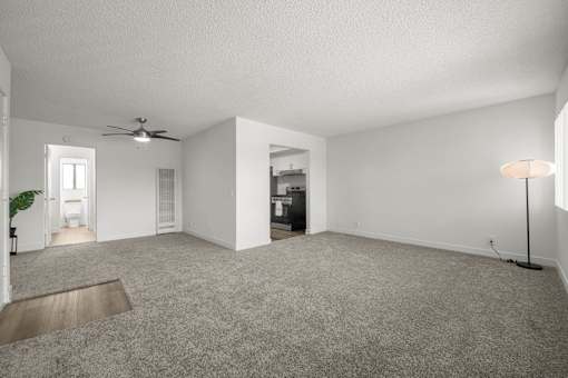 A spacious living room with a ceiling fan and a lamp at Sunset Square, West Covina, 91790