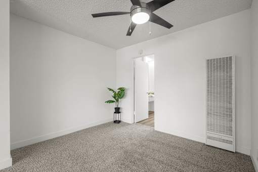 A room with a ceiling fan and a plant in a vase at Sunset Square, West Covina, 91790
