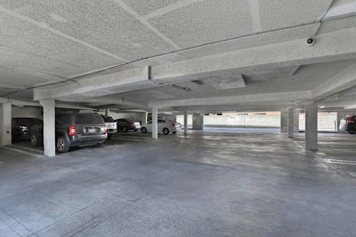 A parking garage with a few cars parked.