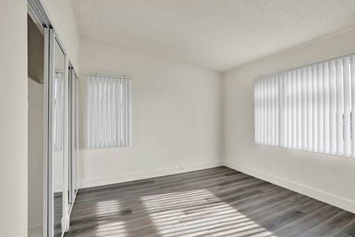 A room with a sliding door and a window with blinds.