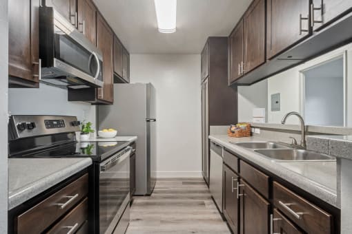 a kitchen with stainless steel appliances and wooden cabinets at Monterra Ridge Apartments, California,91351