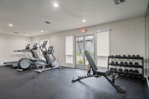 a gym with a lot of weights and mirrors at Monterra Ridge Apartments, Canyon Country, CA