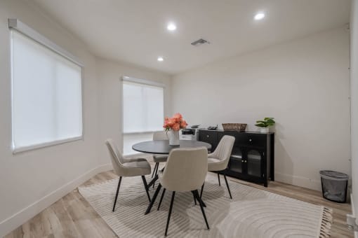 a dining room with a table and chairs and a rug at Monterra Ridge Apartments, Canyon Country, CA