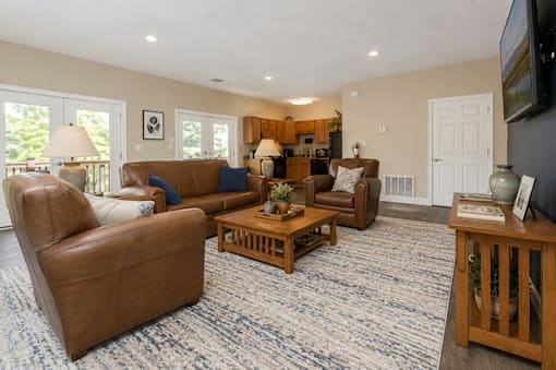 A living room with brown leather furniture and a blue carpet.