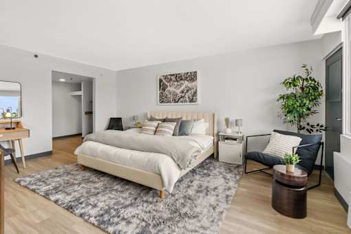 A bedroom with a large bed and a chair.