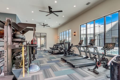 a spacious fitness room with cardio equipment and large windows in Asheville NC