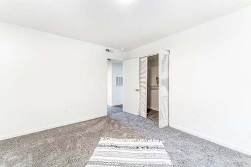 A room with a rug on the floor and a door on the right.