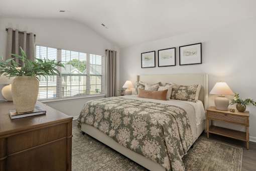 A bedroom with a large bed and a wooden nightstand.
