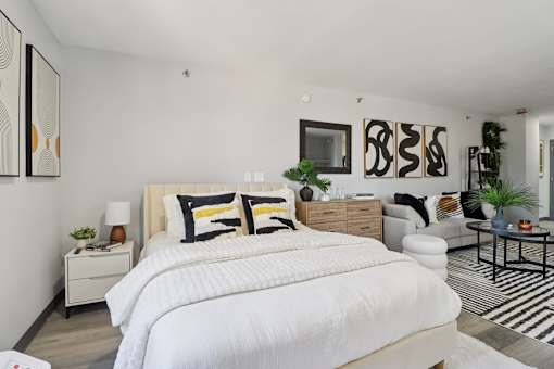 A bedroom with a large bed and a white comforter.