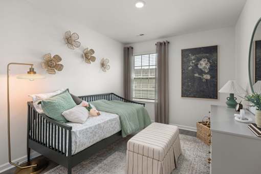 A bedroom with a bed, a nightstand, and a mirror.