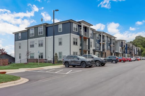a row of apartment buildings with cars parked in front of them in Asheville