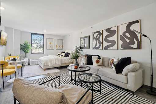 A living room with a white couch, a yellow chair, and a coffee table.