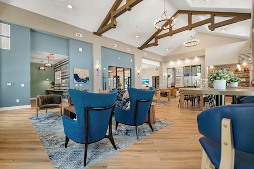 A room with blue chairs and wooden floors.