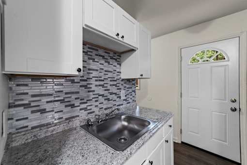 A kitchen with a sink and a door.