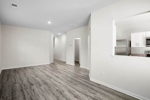 A room with wood flooring and white walls.