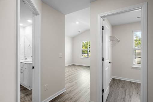 A white bathroom with a sink and a window.