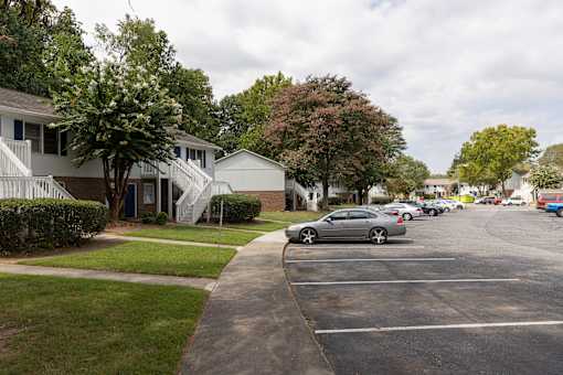 A silver car is parked on the right side of a street.
