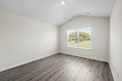 A room with a window and wooden flooring.