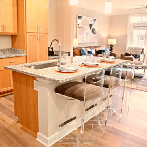 A kitchen with a granite countertop and a dining table set for four.