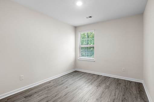 A room with a window and wooden flooring.