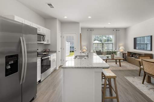 A modern kitchen with a large island and stainless steel appliances.