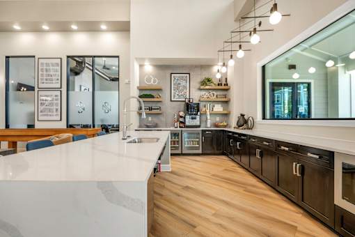 A modern kitchen with a white countertop and wooden flooring.