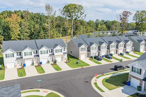 A suburban neighborhood with houses and cars parked on the street.