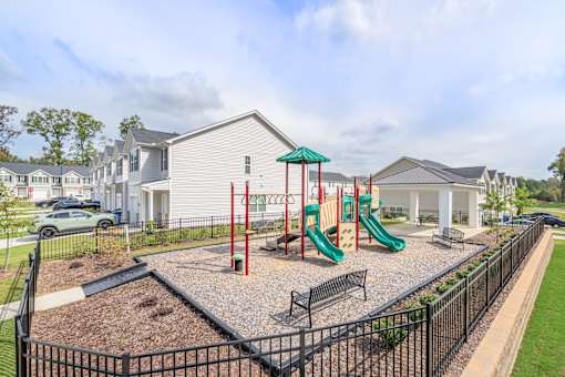 A playground with a green slide and red pole.