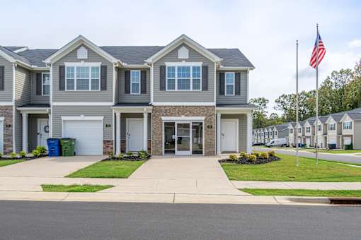 A grey house with a flag on top of it.