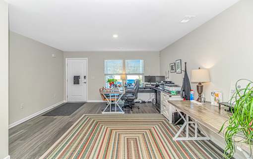 A room with a striped rug and a desk with a computer.
