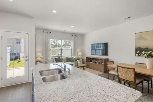 A modern kitchen with a granite countertop and a sink.