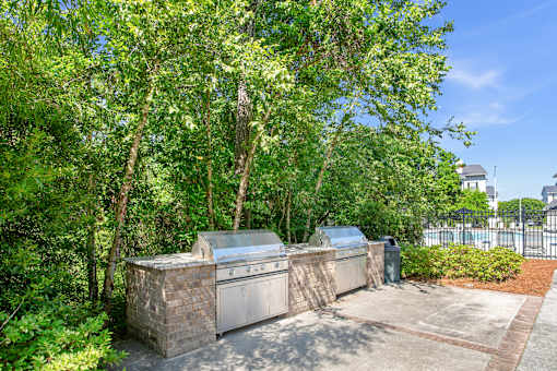 A tree-lined driveway leads to a house with a garage.