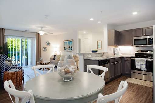 A modern kitchen with a dining table and chairs.